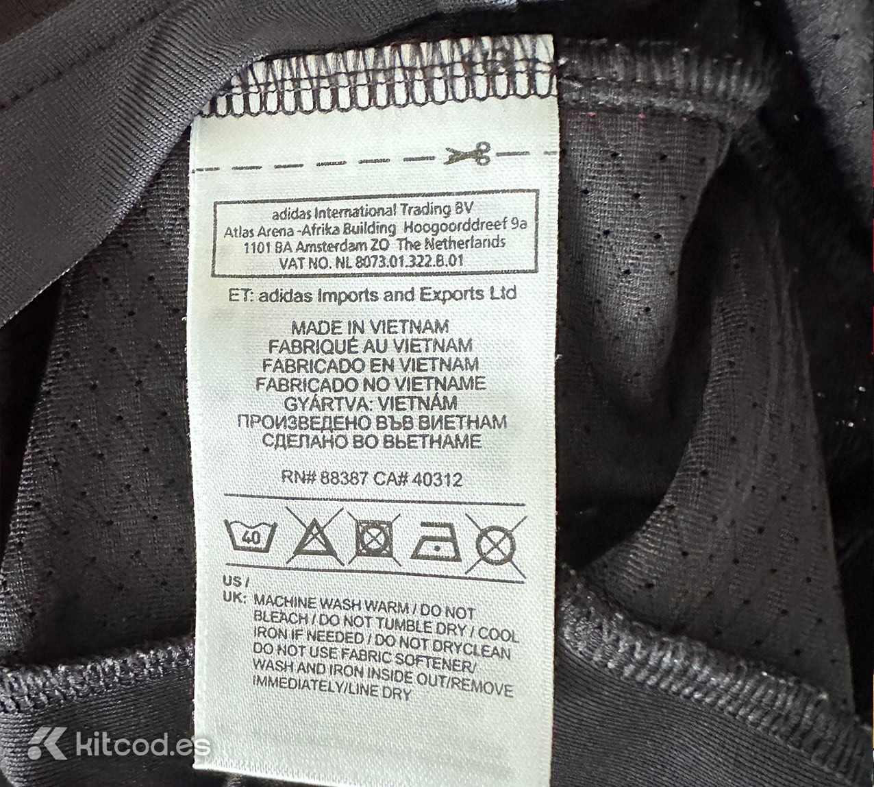 Adidas care label sewn into inner side seam showing washing instructions and manufacturing country